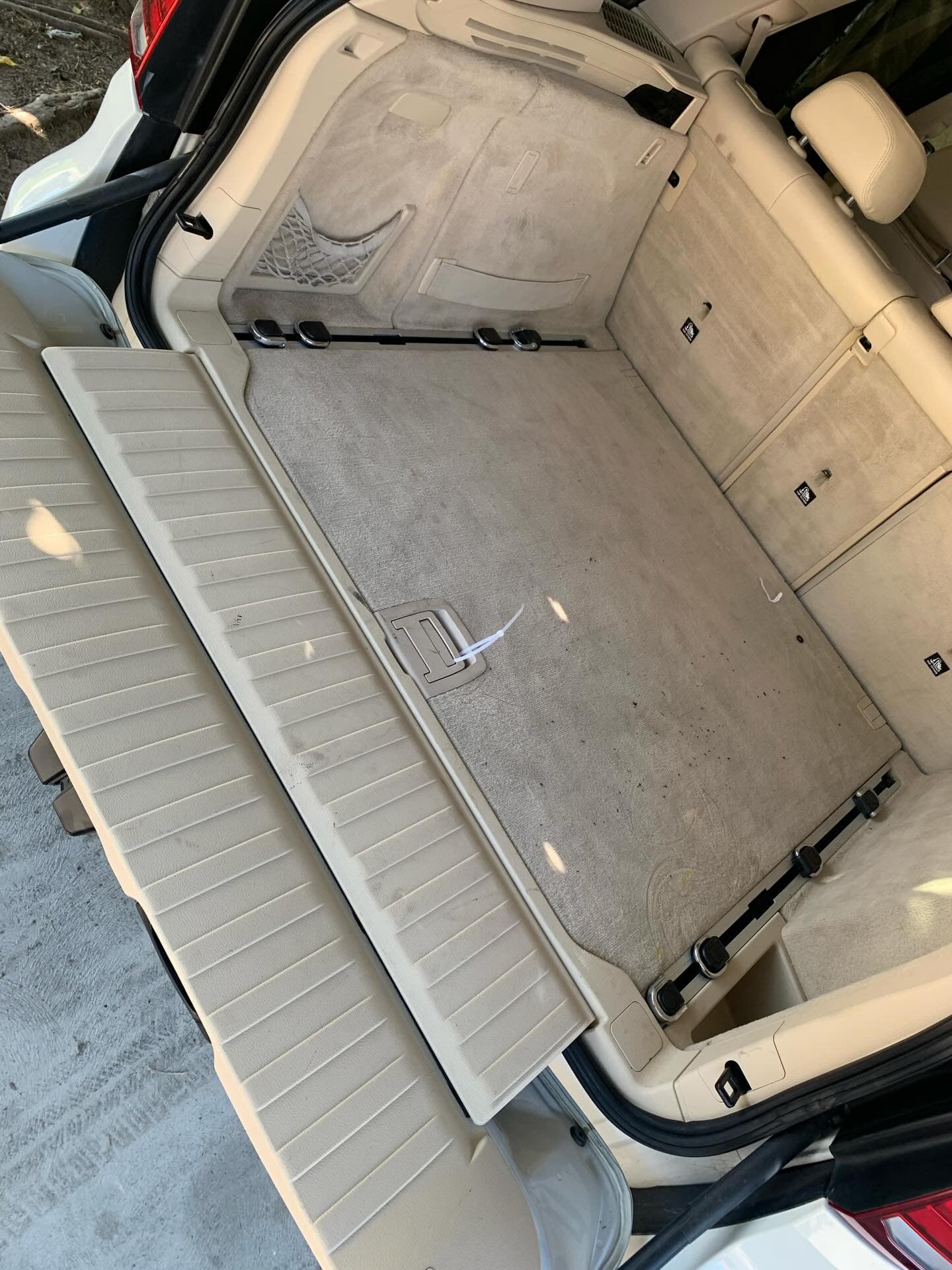 BMW X5 trunk carpet before detailing showing heavy dirt and stains